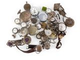 un tas de montres de toutes sortes posées sur une surface blanche