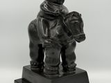 statue of a man riding a horse with a hat on his head