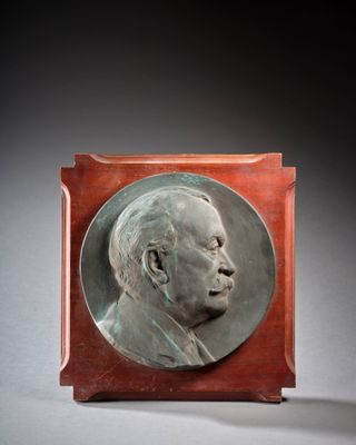 une image représentant une plaque en bronze représentant un homme de profil