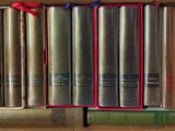 de nombreux livres dans une boîte, ornés de rubans rouges