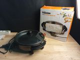 a box of food sitting on a table next to a frying pan
