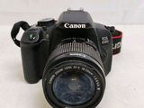a canon camera sitting on a table with a lens attached to it