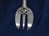 a silver fork and a silver spoon on a blue cloth