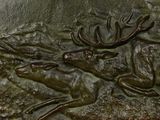 a bronze sculpture of a deer and a deer on a rock