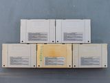 four nintendo game cartridges stacked on top of each other on a table