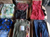 several pairs of clothes are in a cardboard box on a table