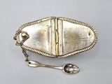 silver plated spoon and spoon rest on a white surface
