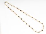 necklace with black and white beads and pearls on a white background