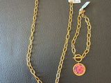 un collier et un bracelet ornés d'une fleur rose sur une chaîne en or