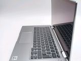 a silver laptop with a black keyboard on a white surface