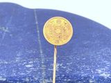 une pièce d'or posée sur une pierre bleue