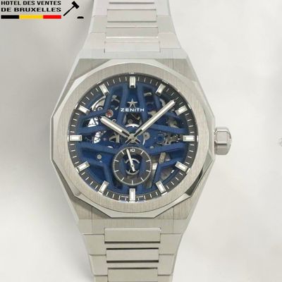 a close up of a watch with a blue dial
