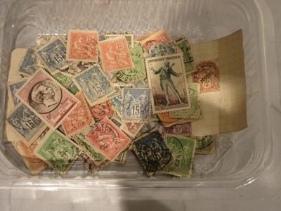 de nombreux timbres de toutes sortes dans une boîte en plastique posée sur une table