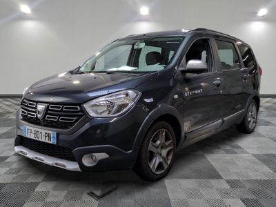 La camionnette grise est garée sur un sol en carrelage à damier.