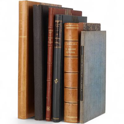 plusieurs vieux livres empilés sur une surface blanche