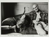 black and white photograph of a man sitting on a couch with a cat