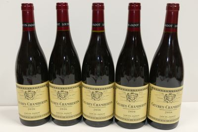 six bouteilles de vin sont alignées sur une surface blanche