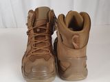 two pairs of brown hiking boots sitting on a white surface