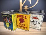 three cans of oil sitting on a table next to each other