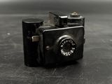 a small black camera sitting on a black surface