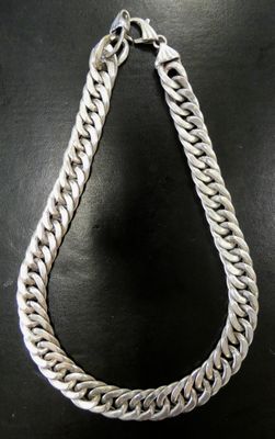 silver chain necklace on a black surface