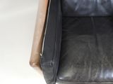 a black leather chair with a brown leather seat