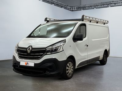 La camionnette blanche est garée dans une grande pièce.