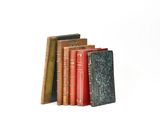 several books are stacked on top of each other on a white surface