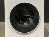 vue de face d'une machine à laver blanche posée sur un plan de travail