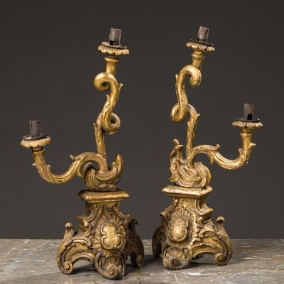 a pair of antique brass candelabs on marble table