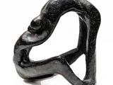 a black sculpture of a man and a woman holding each other