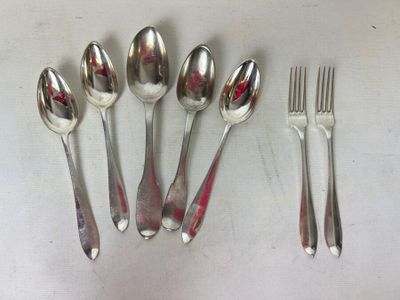 five spoons, two forks, and a knife on a table