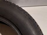 a close up of a tire on a white surface next to a white wall