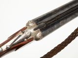 an old gun with a long wooden handle and a chain on a white background