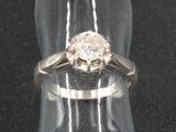 une photo d'une bague en diamant posée sur un présentoir transparent pour bagues