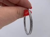 someone is holding a ring with a red heart on it