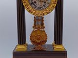 une horloge posée sur un support sur lequel se trouve une autre horloge
