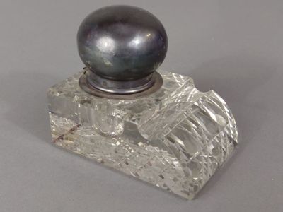 un flacon de parfum en verre orné d'une boule noire