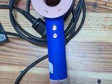 a blue blow dryer sitting on top of a wooden table