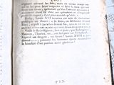 un livre ouvert avec une écriture dessus, posé sur une table