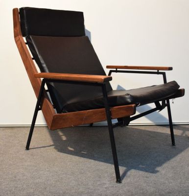 une photo d'une chaise avec une assise en cuir noir dans une pièce