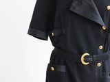 une photo d'une robe noire ornée de boutons dorés