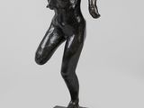une statue en bronze représentant un homme en train de courir, posée sur un socle en marbre
