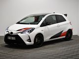 La Toyota Yaris blanche est garée dans une pièce dont le sol est à carreaux.