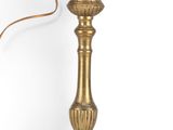 an antique brass candle holder with a single candle on top of it