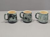 three coffee mugs sitting on top of a table next to each other