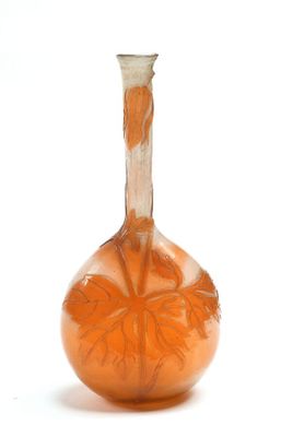 un vase en verre orange orné d'un motif de feuilles