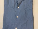 une chemise bleue à pois blancs posée sur une table