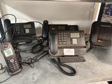 de nombreux téléphones qui prennent la poussière sur une étagère