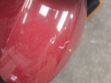 a close up of a red motorcycle parked on the street